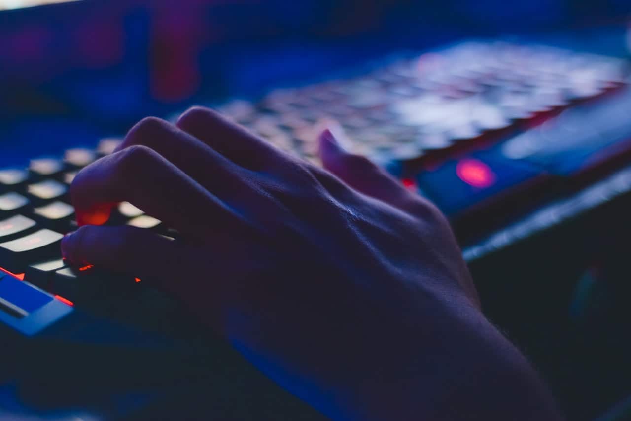 Hand on keyboard in dark room